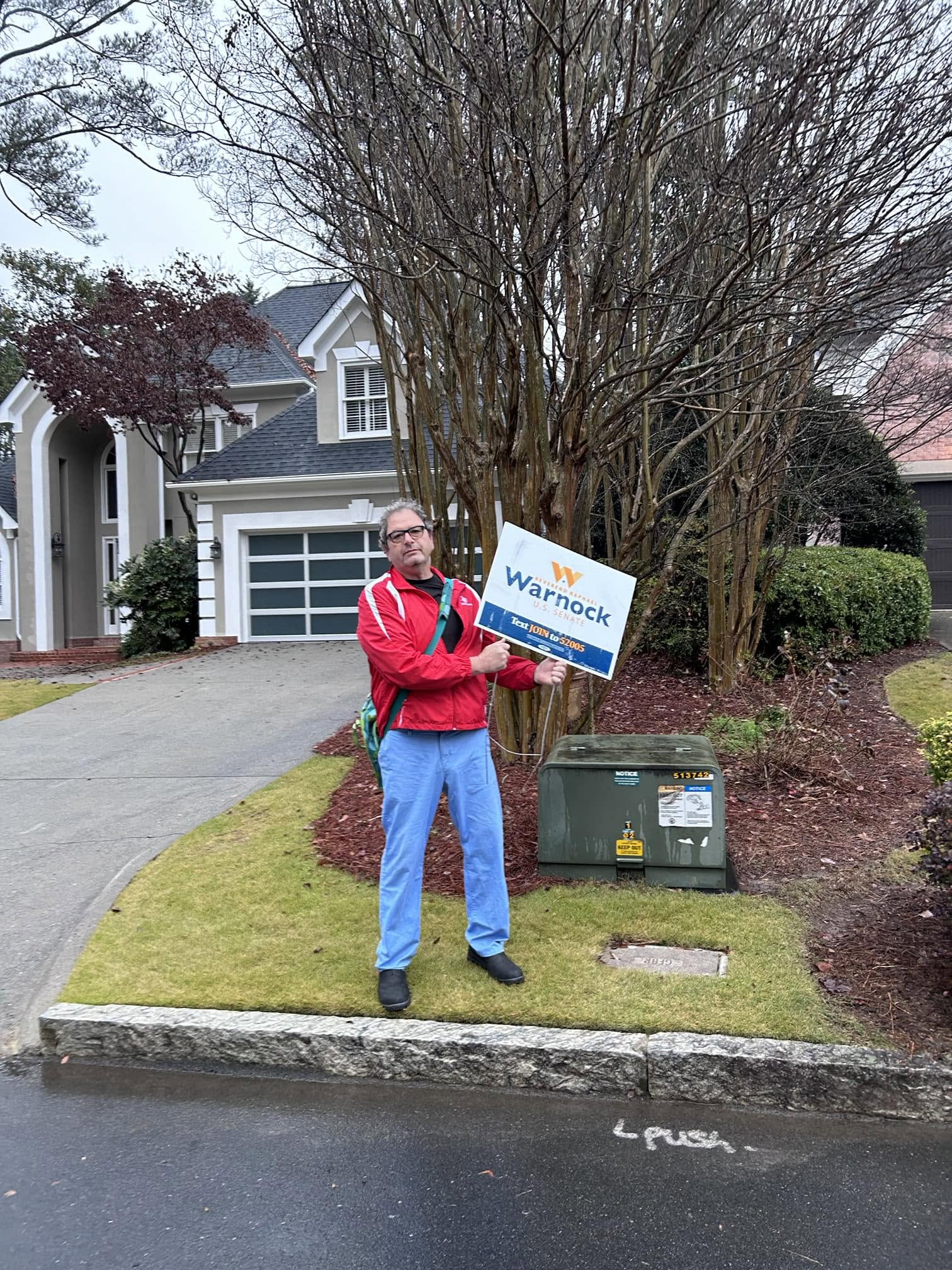 Steve holding a campaign sign outdoors
